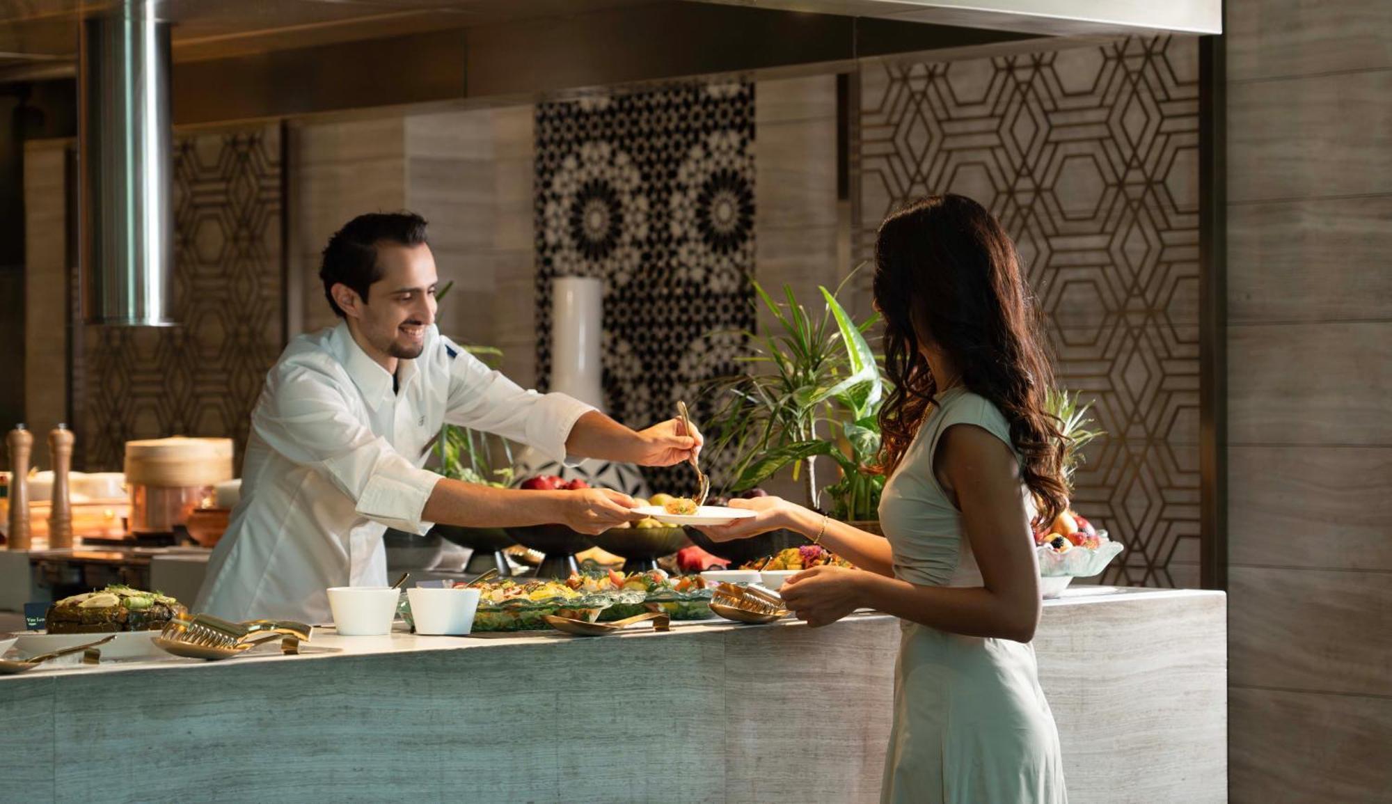 Fairmont Эр-Рияд Экстерьер фото A chef serving a guest at the buffet